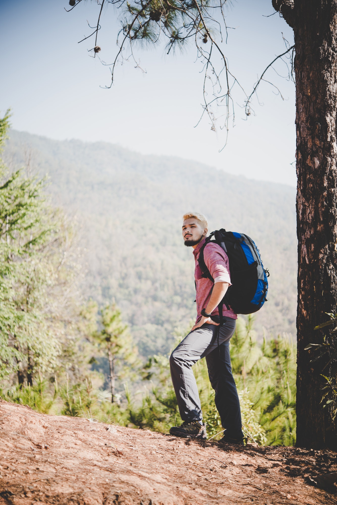 Hiker with big traveling backpack traveling to the mountain.