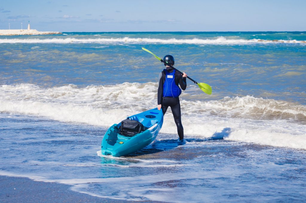 Man with kayak. Traveling by kayak. Leisure activities on the water.